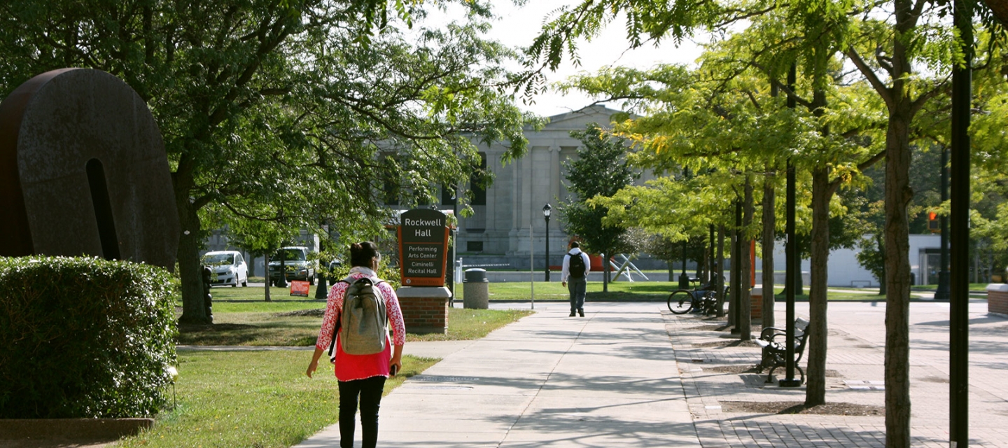 Student walking on campus near Rockwell